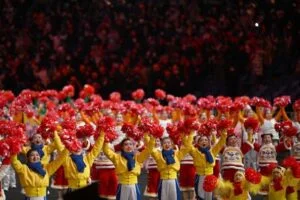 Artiesten zwaaien bij de aankomst van China's president Xi Jinping (niet op de foto) voor het begin van de openingsceremonie van de Olympische Winterspelen van Peking 2022, in het Nationale Stadion, bekend als het Vogelnest, in Peking, op 4 februari 2022. (foto: Manan Vatsyayana / AFP/Getty)